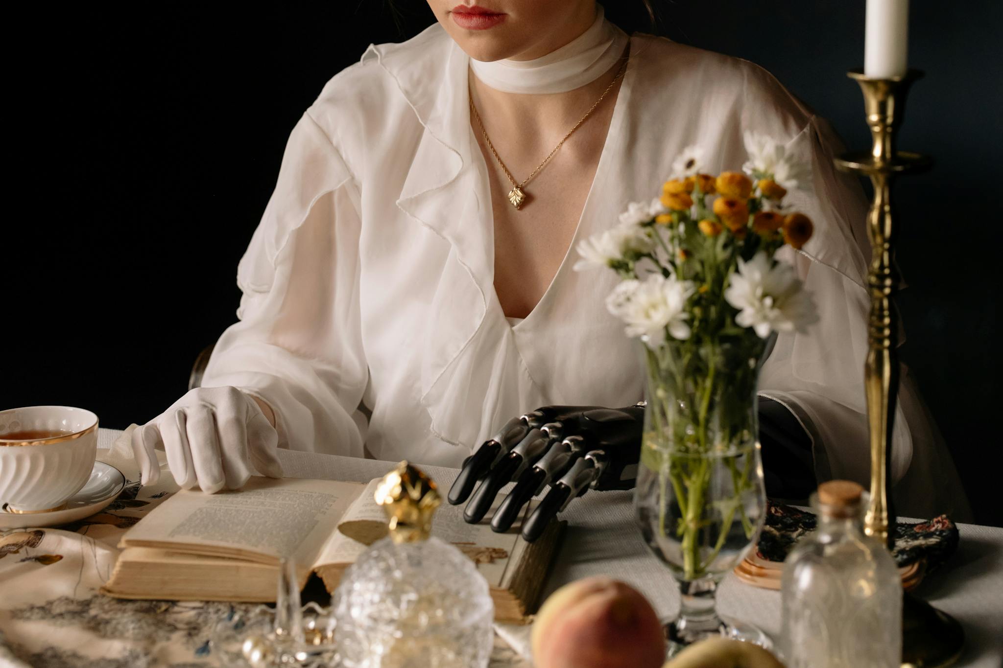 Elegant woman with prosthetic arm at a vintage table setting, embodying futuristic elegance.
